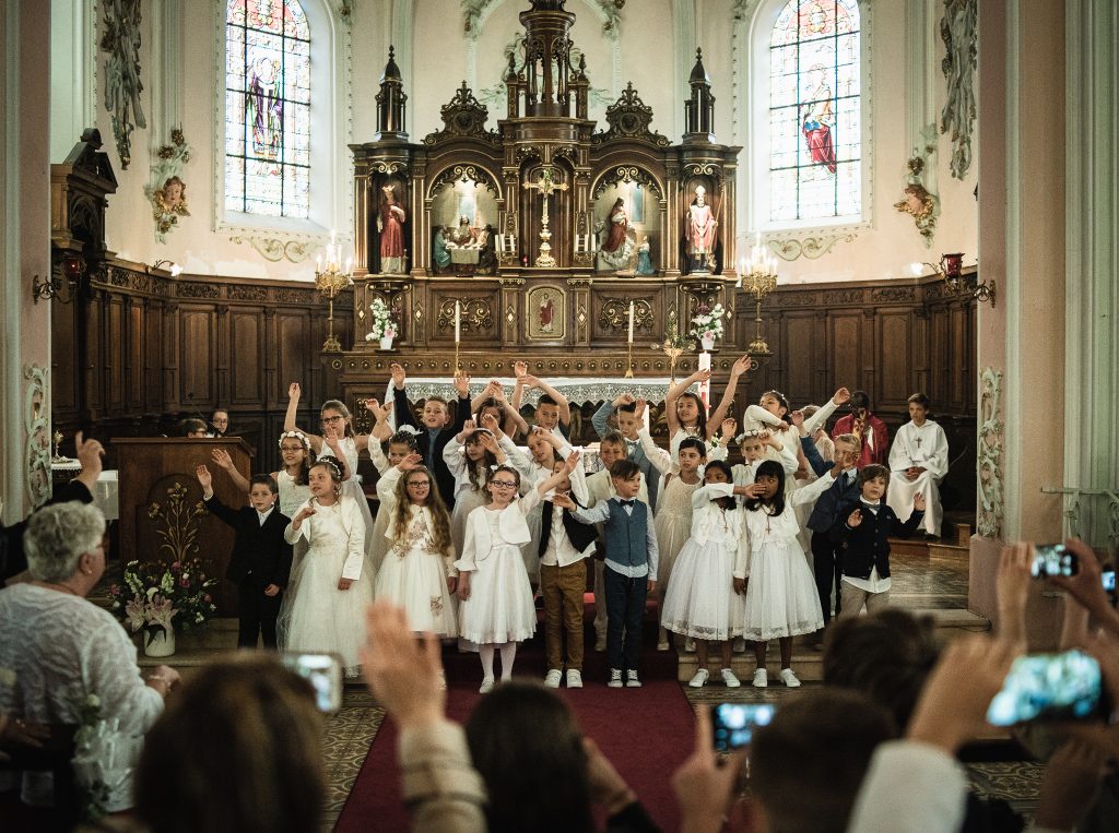 Photo of group of people looking childs for first communion at the end of ceremony
